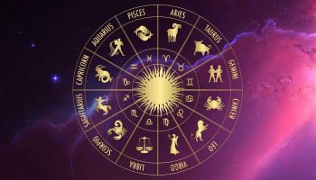 Znamení zvěrokruhu uspořádaná v astrologickém kruhu se zlatým sluncem uprostřed na fialovém vesmírném pozadí.
