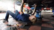 Automechanik opravuje podvozek auta v autoservisu – údržba spolehlivých automobilů a kontrola technického stavu